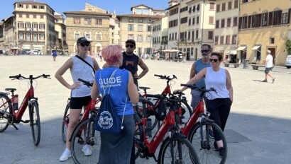 A group of 4 listens to the guide during an e-bike tour in Florence