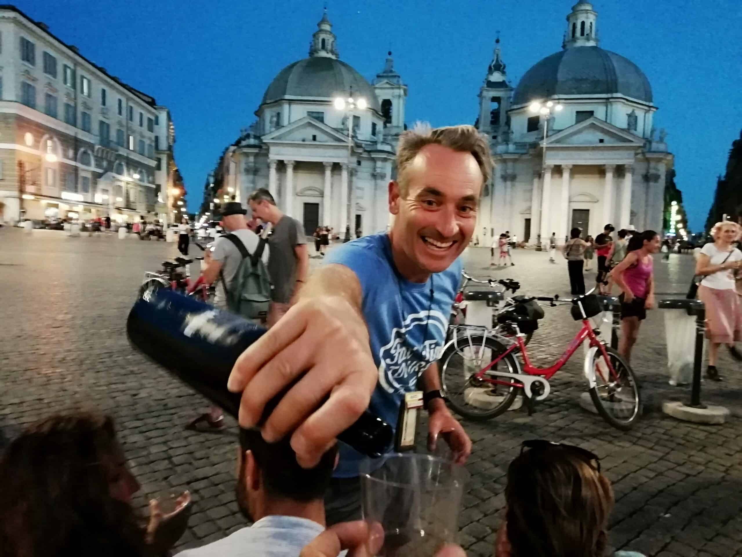 The guide pours wine in front of the Santa Maria churches in Rome, Italy