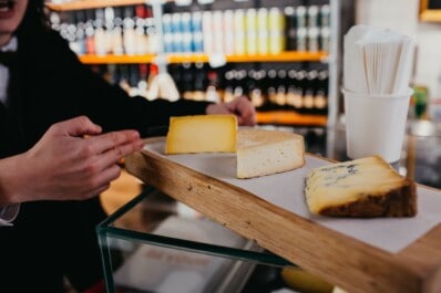 Three types of cheese on a wooden board