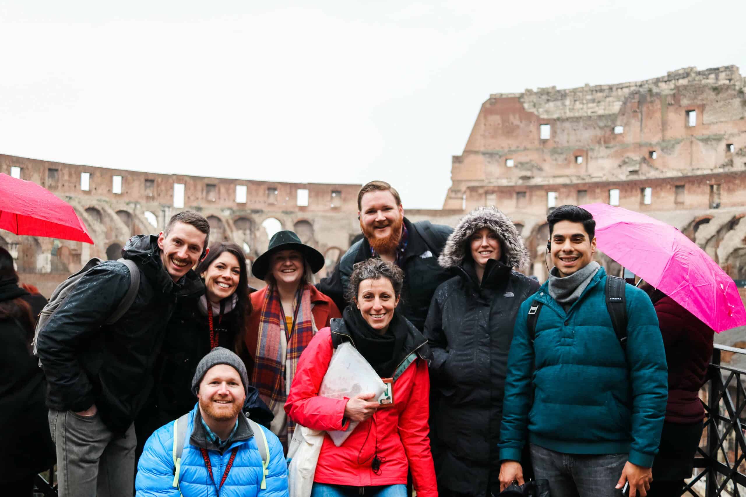 A group poses for a photo inside the Colosseum in Rome, Italy