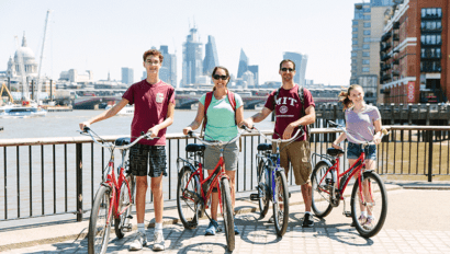 A family poses with their bikes along the Thames River